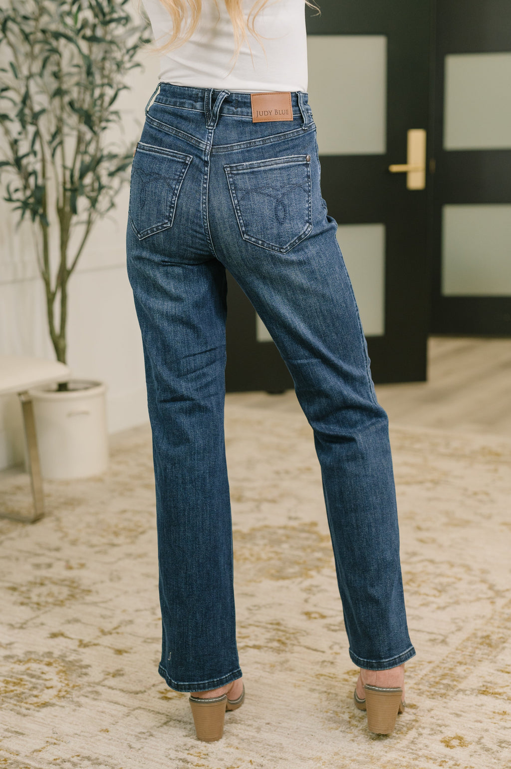 High-waist bootcut jeans in mid-blue denim with front pockets and stitched hem cuffs