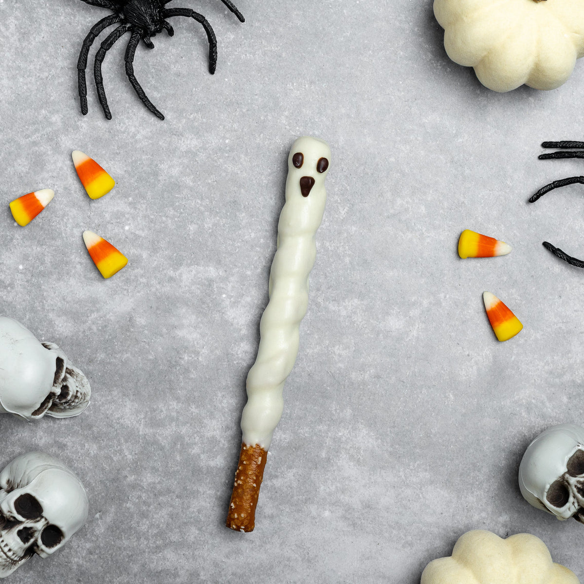 Halloween white ghost chocolate pretzel rod with dark eyes and open-mouth details