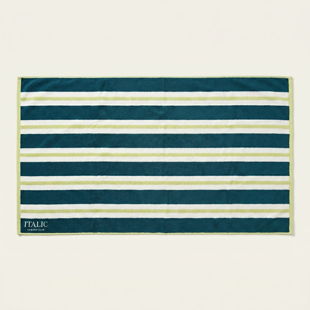 Cotton beach towel with teal, navy, and white horizontal stripes and “ITALIC” label