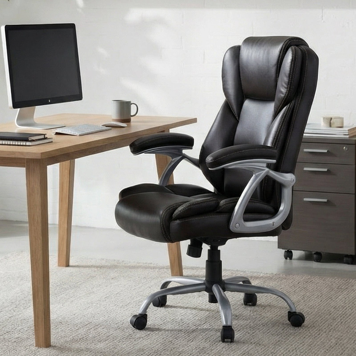 Black leather ergonomic office chair with high padded backrest, armrests, and caster base.