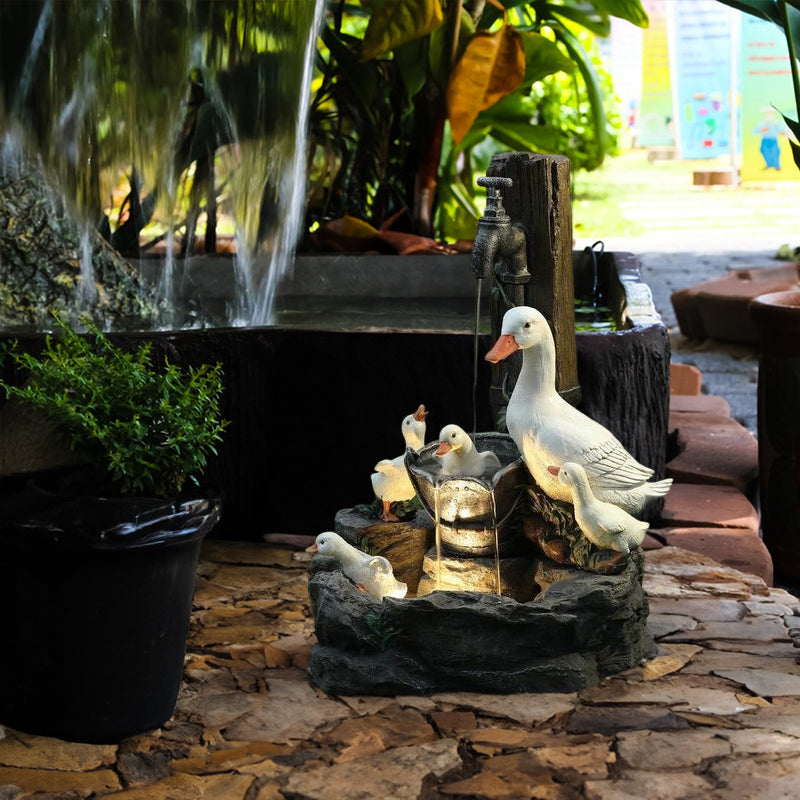 Resin outdoor fountain with white ducks, squirrels, and tall water stream