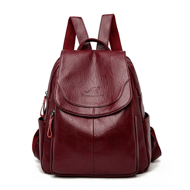Women’s dark red backpack with front flap pocket, top handle, and side zipper details