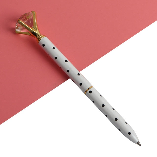 Kawaii ballpoint pen with white barrel, black dots, and gold gem-style cap