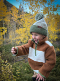 Tan-and-white sherpa pullover hoodie sweatshirt with green zipper trim