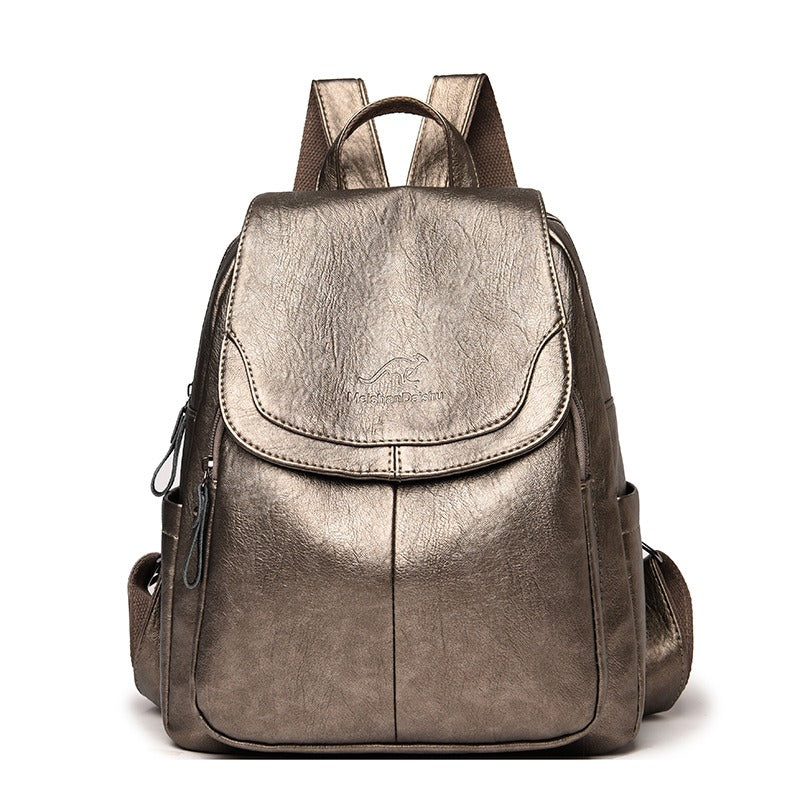 Women’s brown metallic backpack with front flap pocket, top handle, and side zipper details