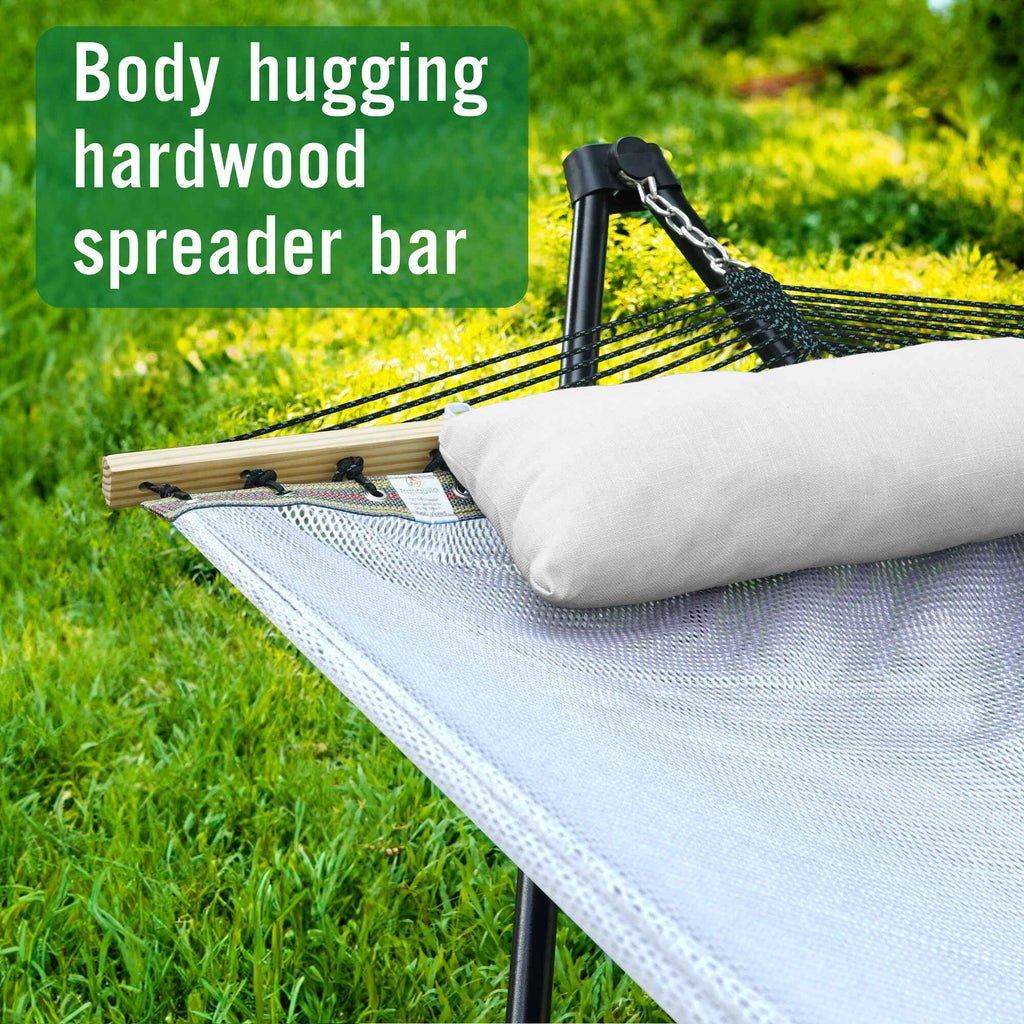 Outdoor hammock with stand, white pillow, and wood spreader bar with netting