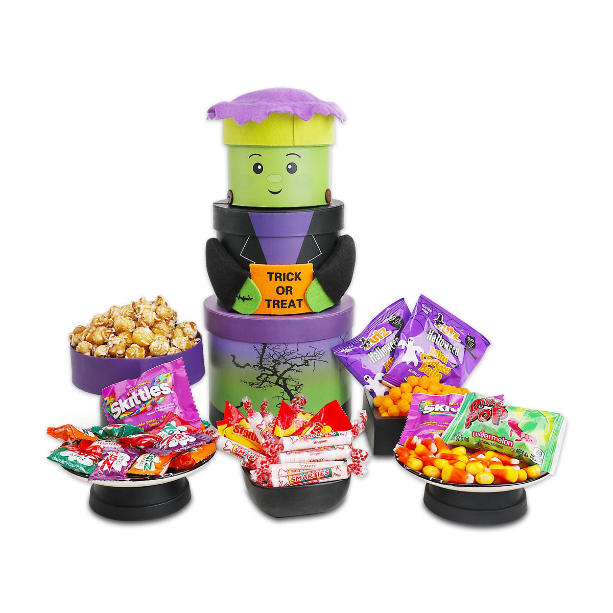 Three-tier Halloween gift tower with green monster face, purple roof, and candy bags