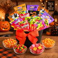 Halloween treat gift basket with assorted candy packs in black bucket, orange bow