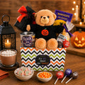 Halloween gift basket with plush bear, jack-o'-lantern accent, and wrapped chocolate treats
