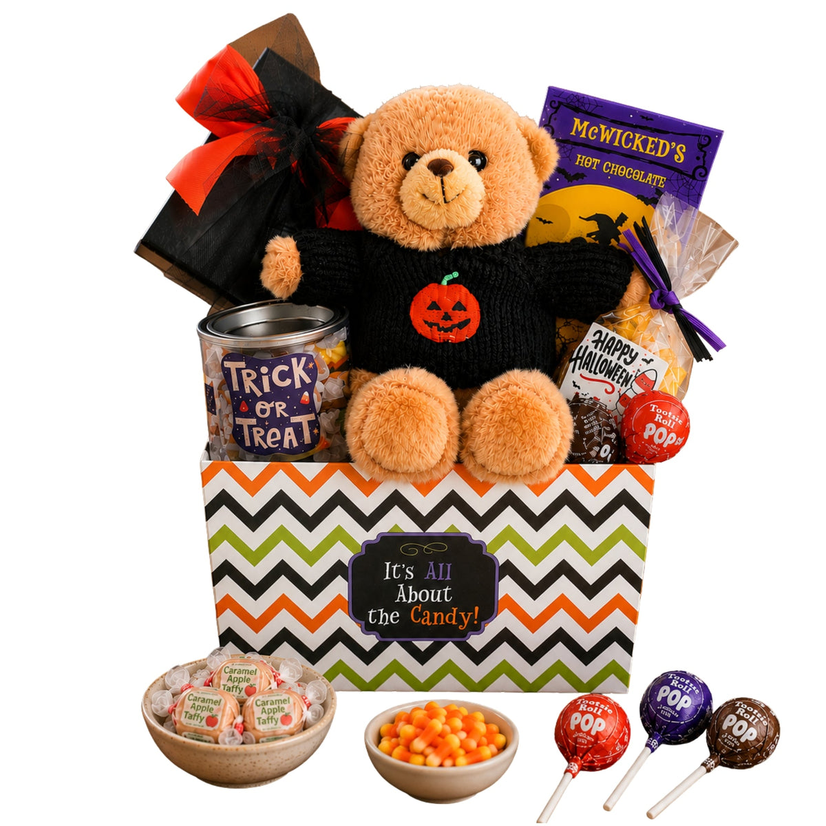 Halloween gift basket with plush bear on chevron-patterned bag, candies and hot chocolate mix