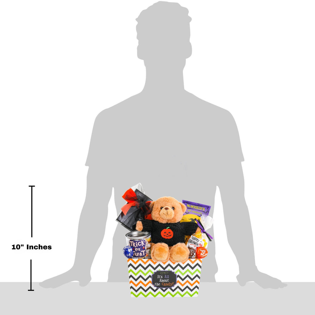 Halloween gift basket shown on a person, with plush bear, candies, and hot chocolate packets