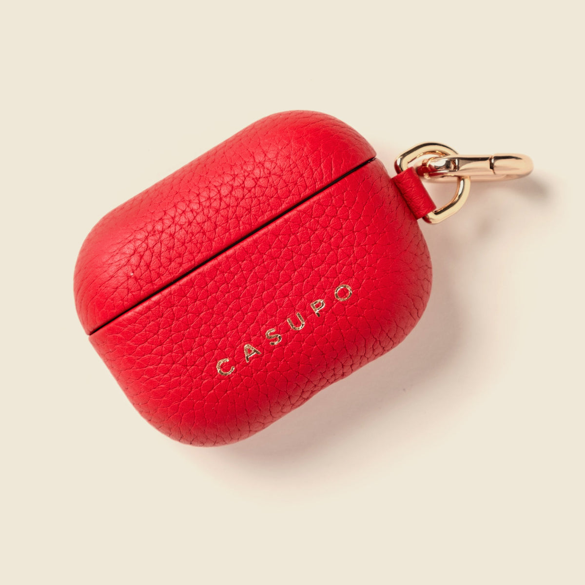 Red leather AirPod case with carabiner keyring and CASUPO logo, top view