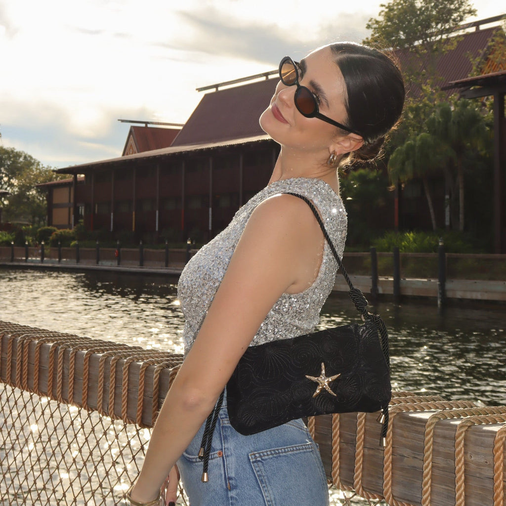 Black starfish-accent shoulder bag with braided cords and small tassels