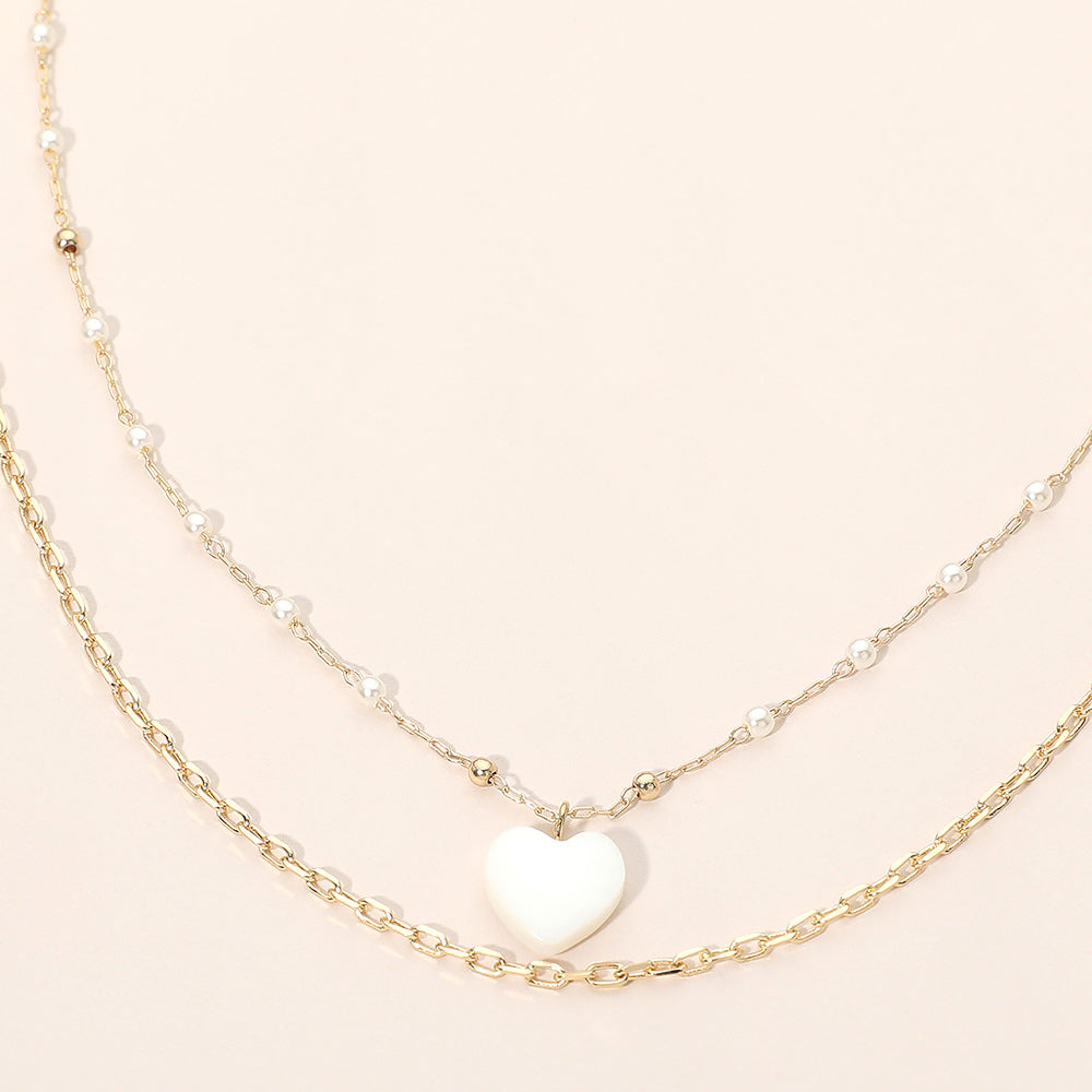 Layered necklace with cream mother-of-pearl heart pendant on gold-tone chains