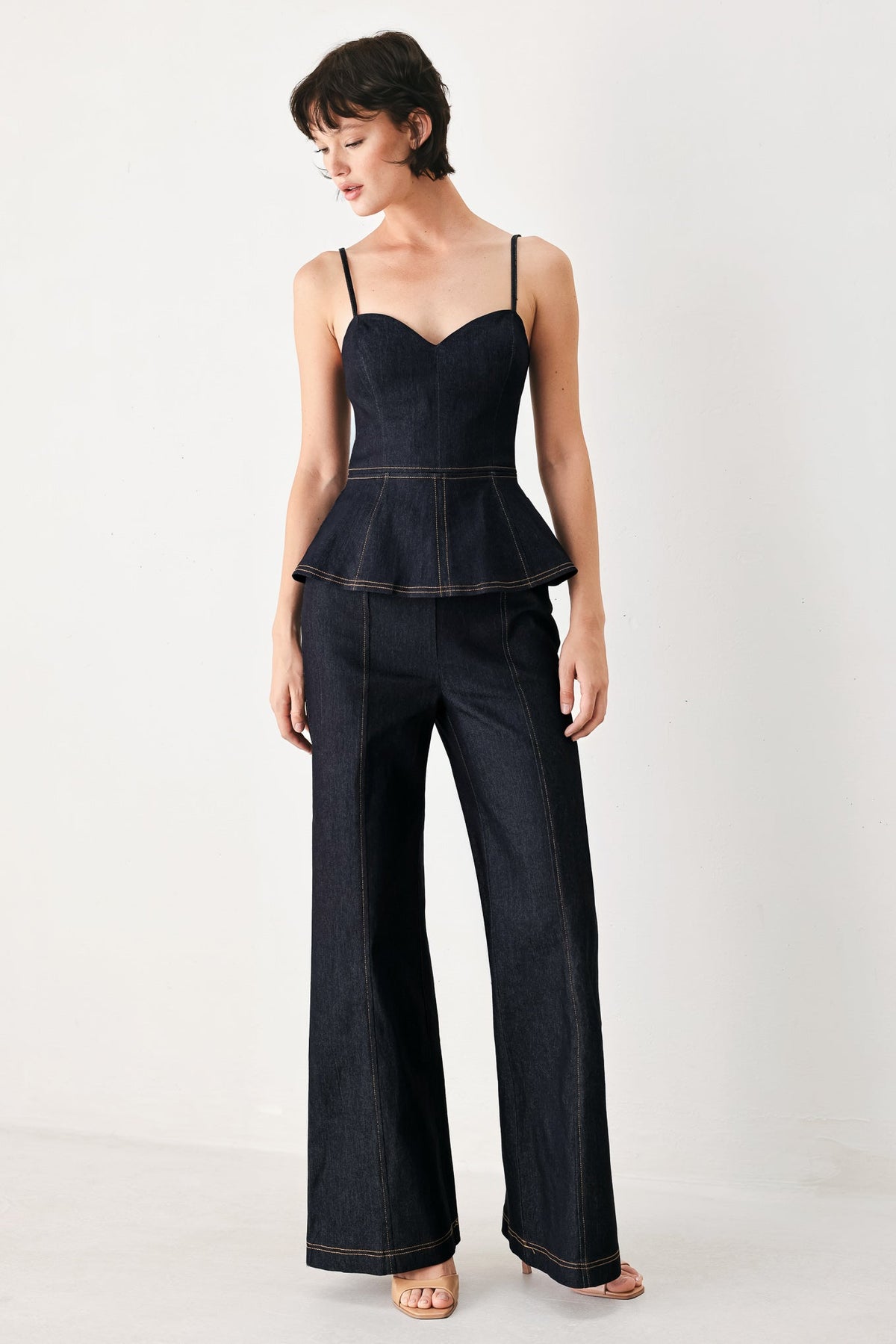 Dark denim jumpsuit with sweetheart bodice, thin straps, peplum waist, wide legs