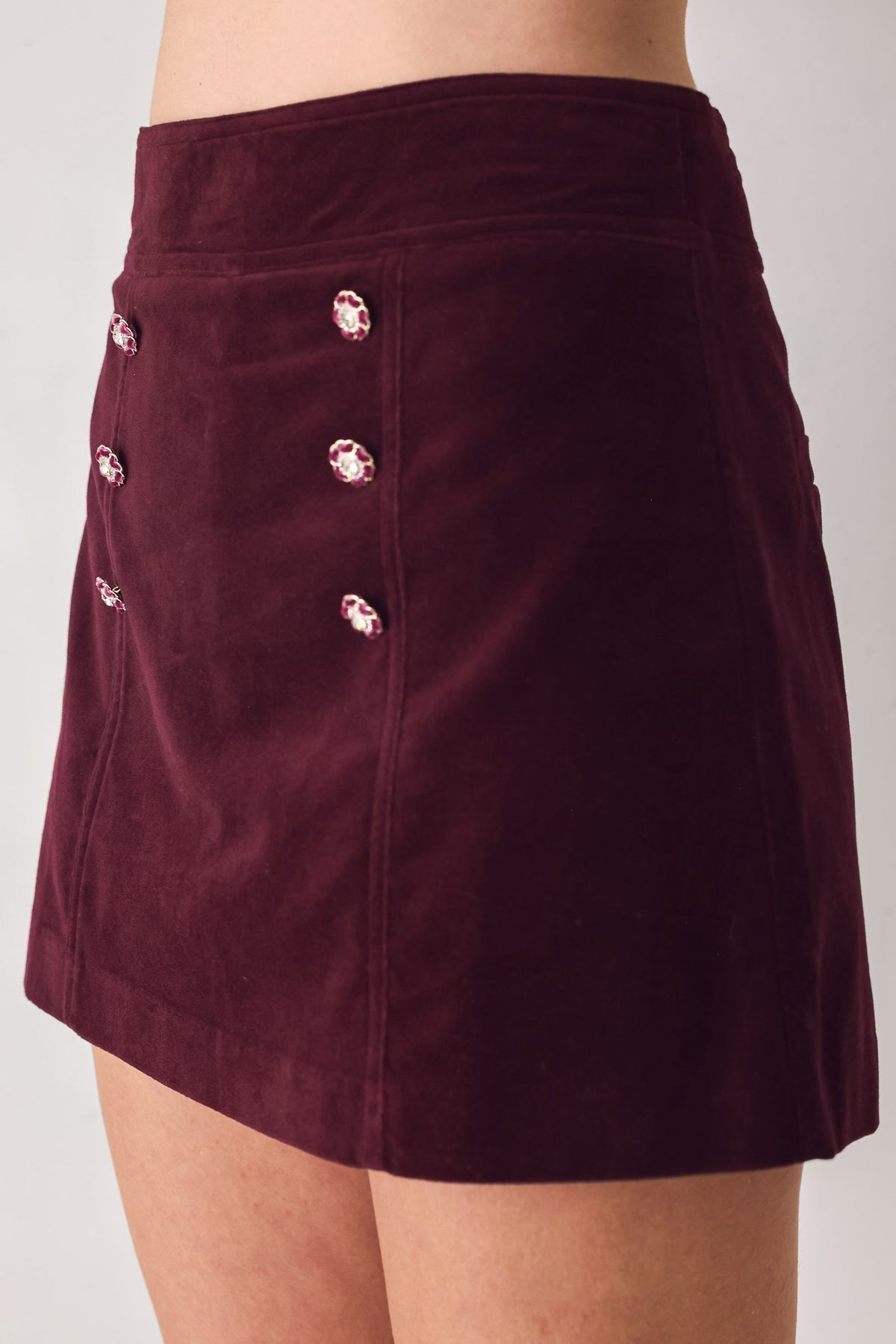 Burgundy velvet skort with floral button trim and seam detail