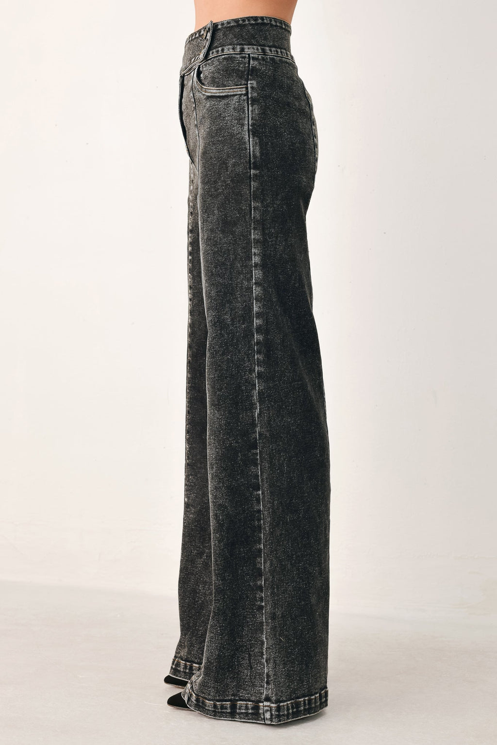 Black wash denim pants, side view, wide straight leg with stitched seams