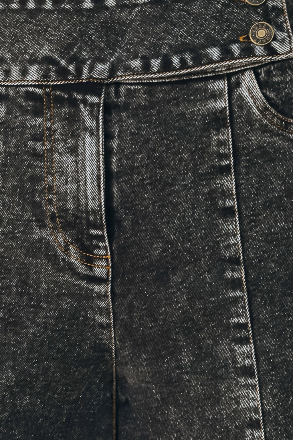 Black wash denim close-up showing front seam panel and stitch detailing