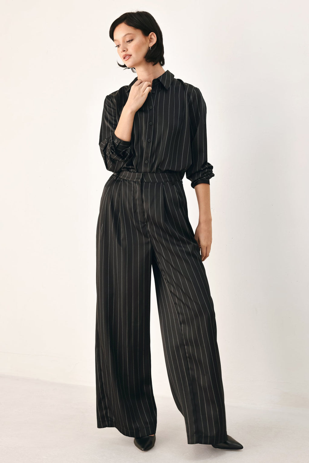 Black pinstripe wide-leg pants with elastic waist and flowing wide legs