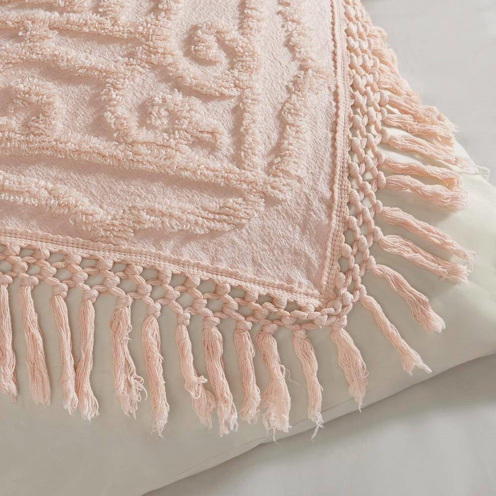 Pink blush chenille bedspread corner with braided fringe tassels and raised texture
