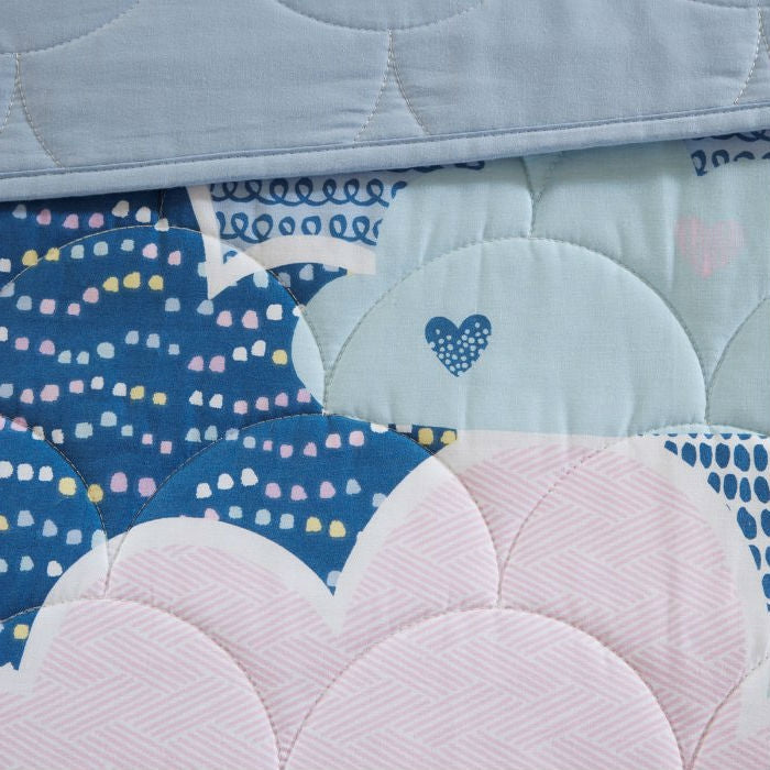 Close-up of blue and pink quilt coverlet with cloud and heart stitched details
