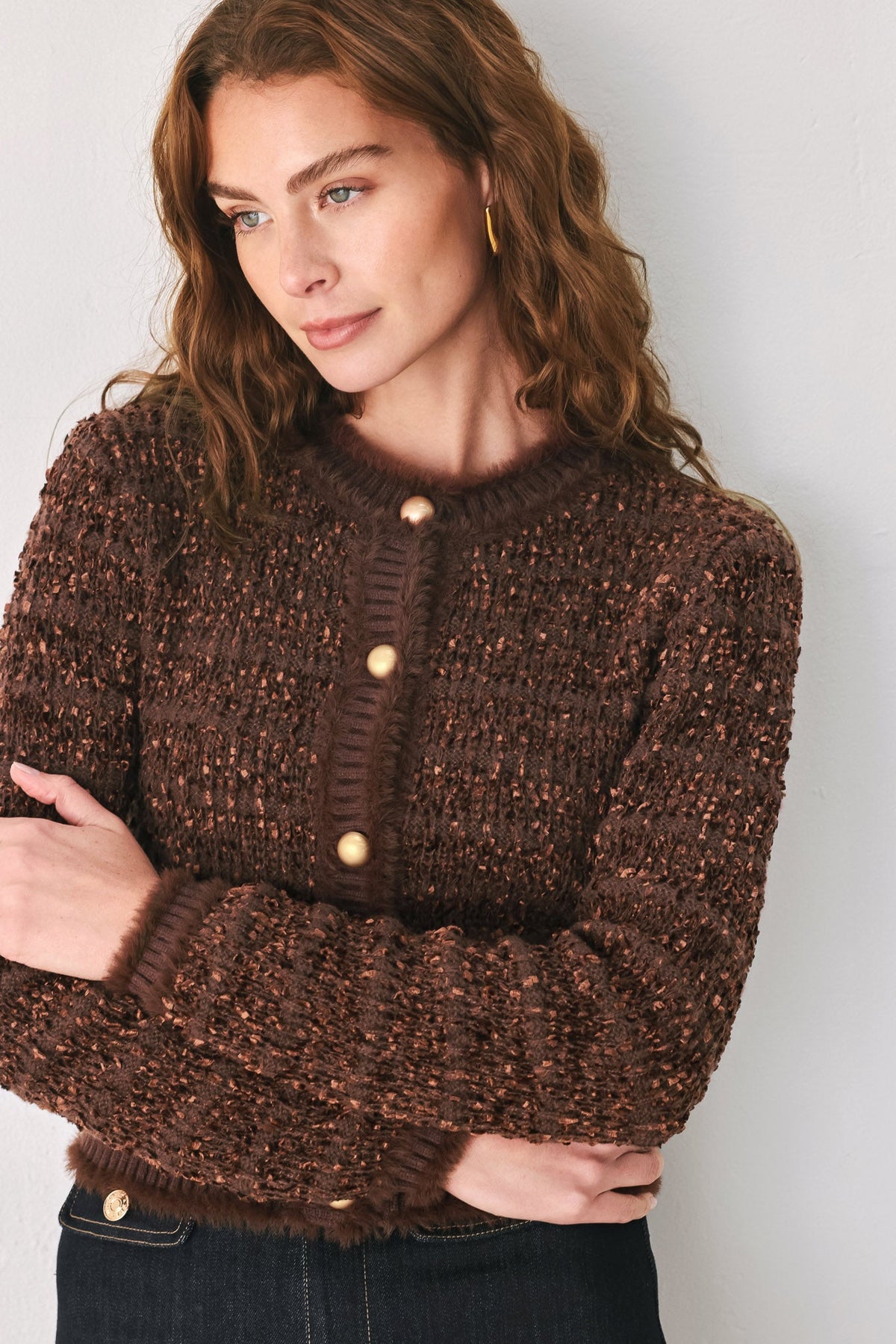 Close-up of brown cropped cardigan neckline with round jewel buttons