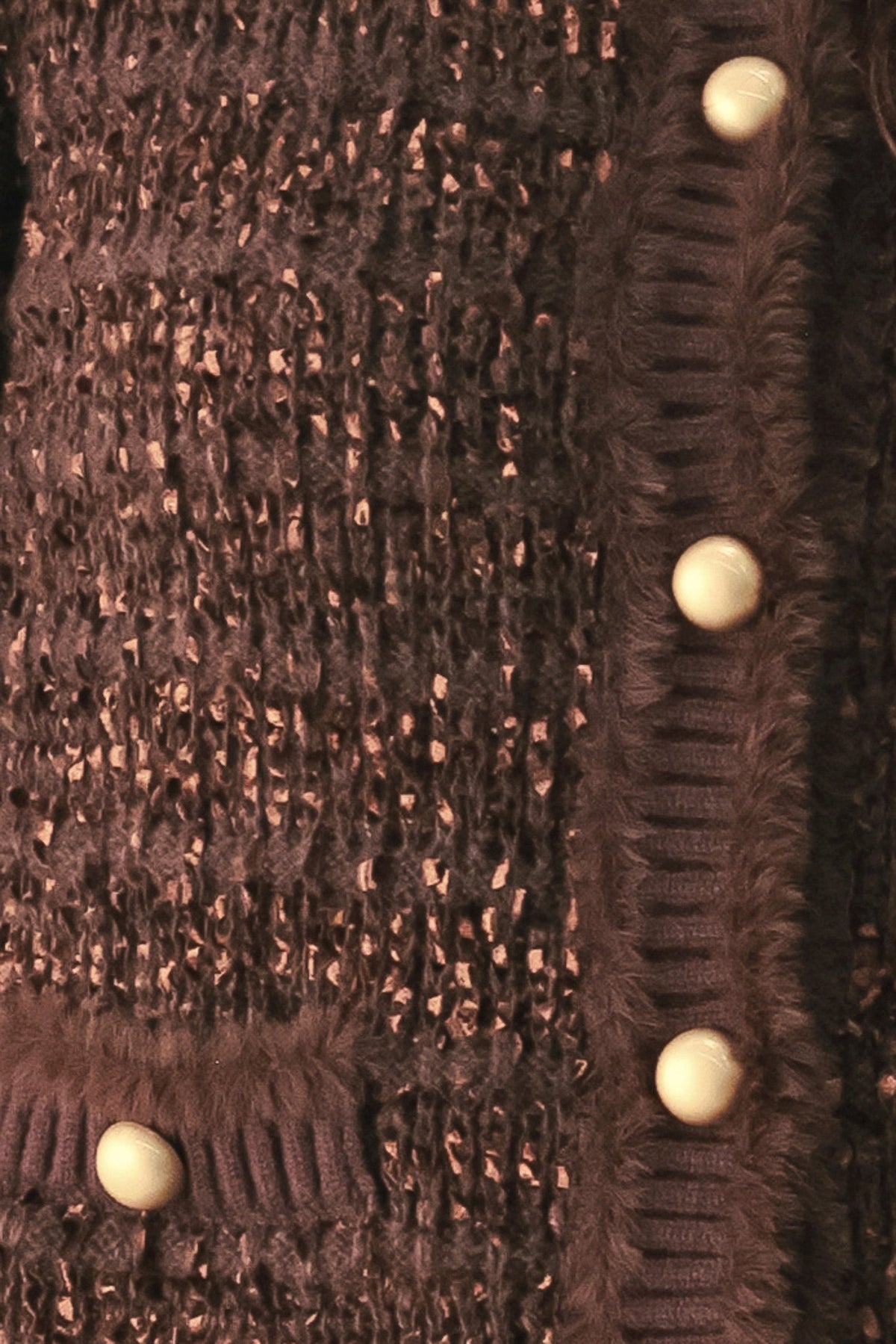 Brown textured knit cardigan fabric detail with round jewel buttons close-up