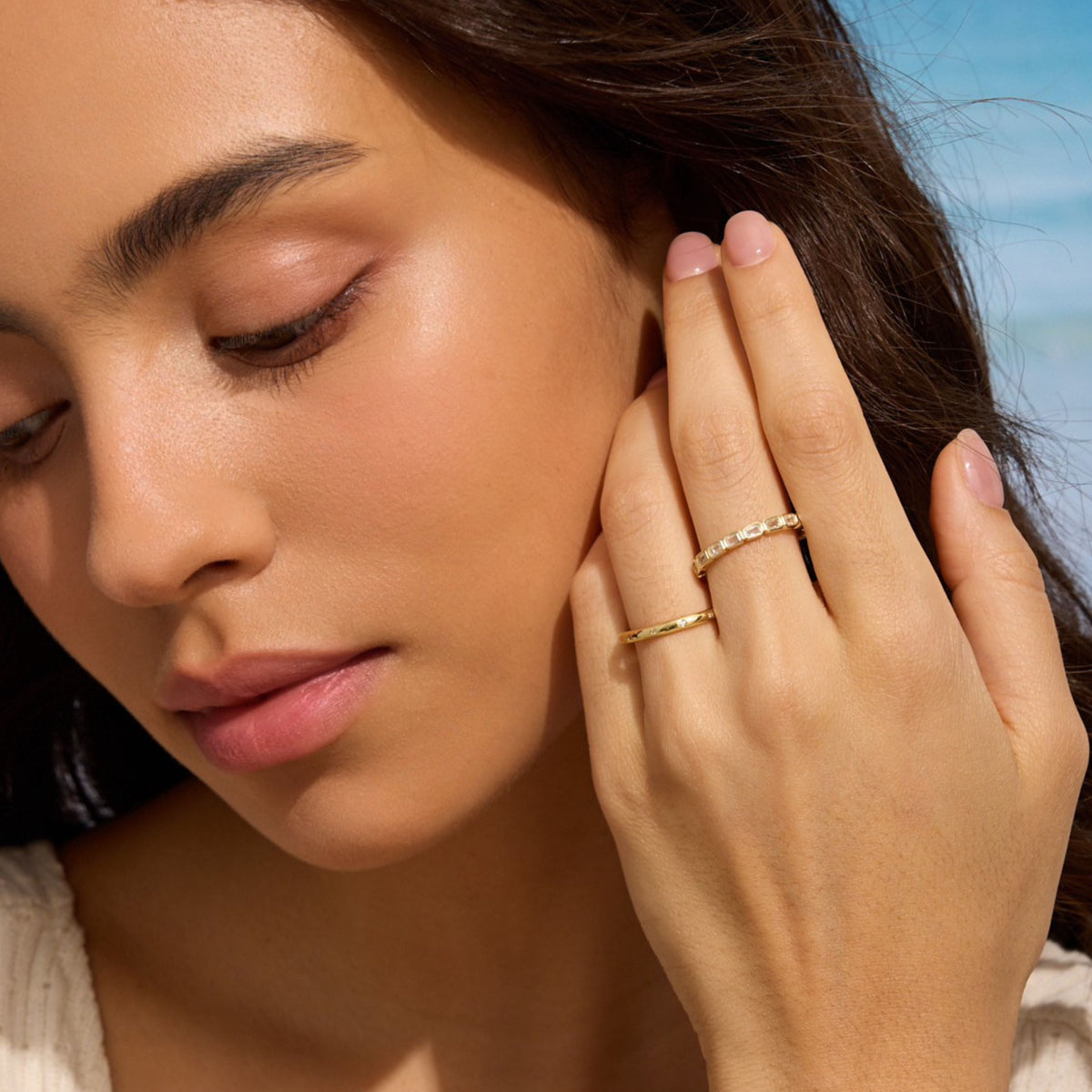 Gold-tone ring with rectangular clear stones on finger