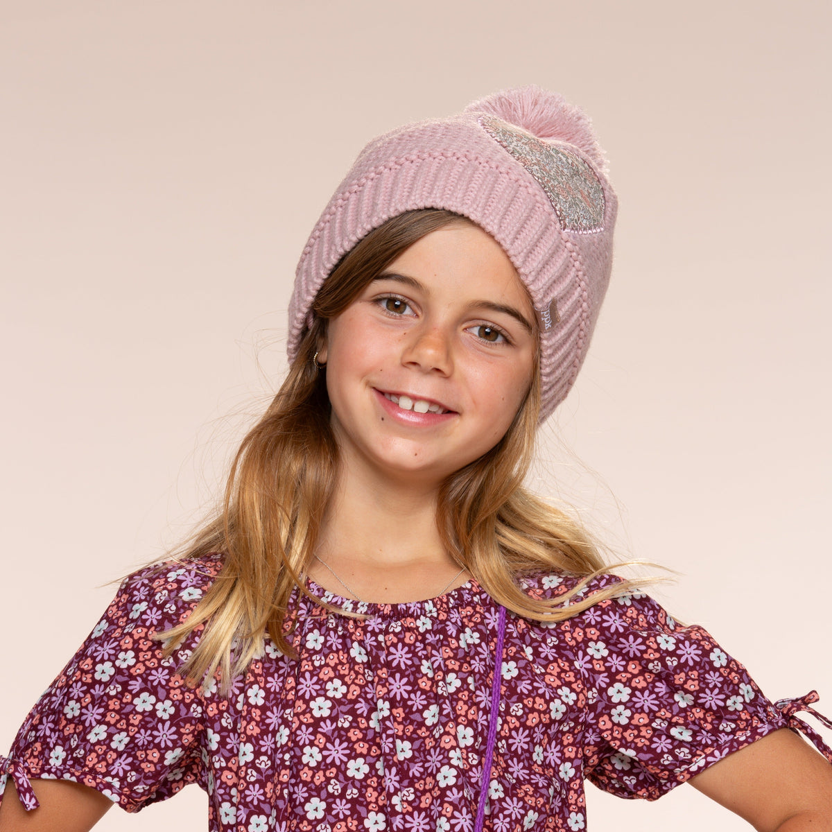 Mauve knit pom-pom beanie and floral heart patch with rabbit mittens on child