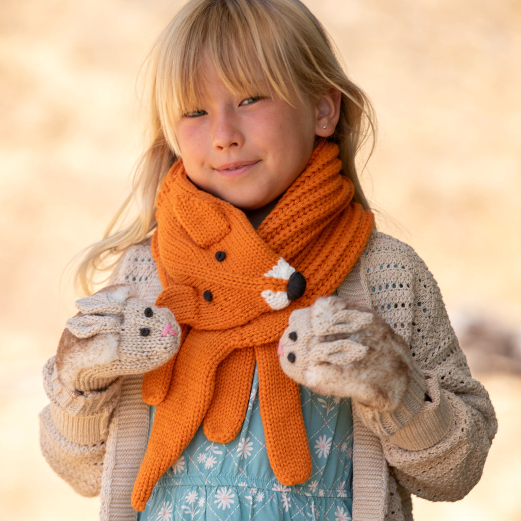 Orange fox neck scarf worn by child, with long ear ends and stitched paw detail
