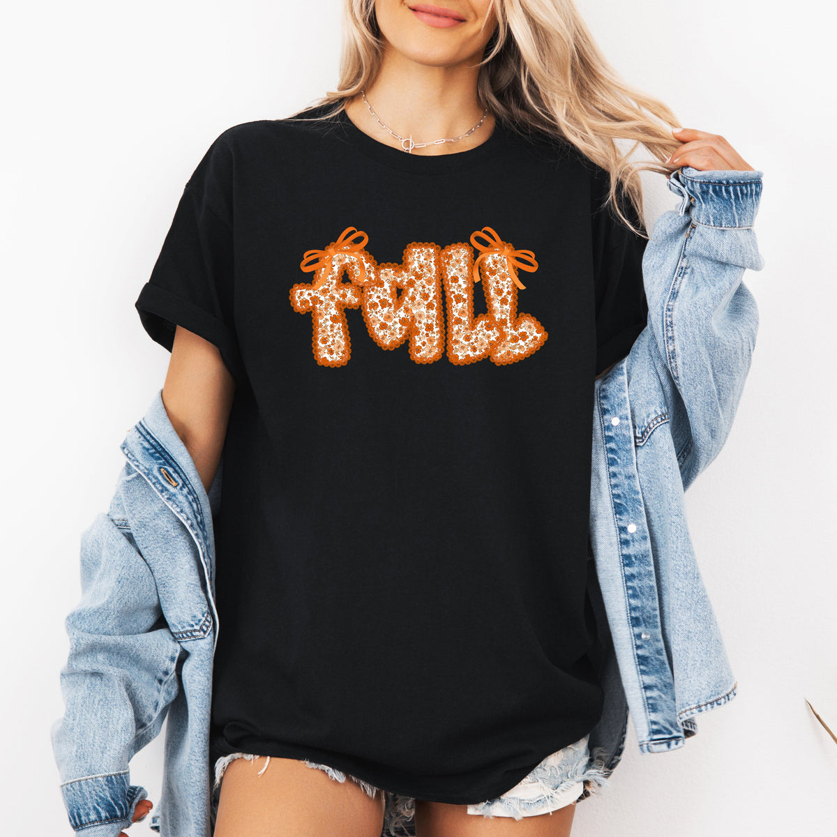 Black graphic tee with orange glitter "Fall" text centered.