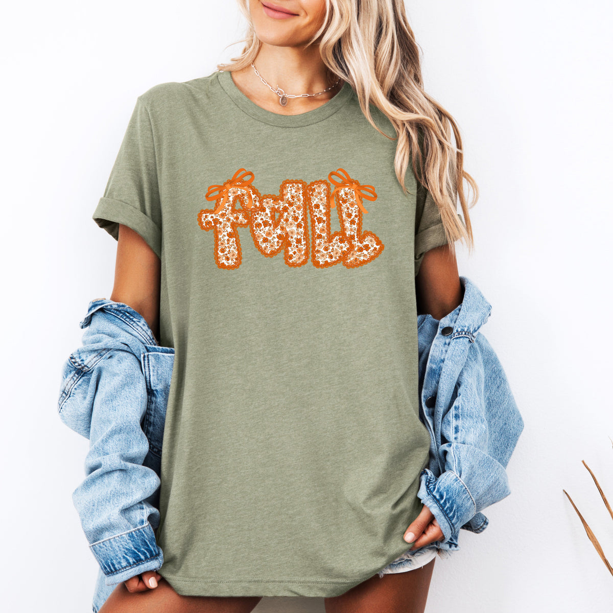 Sage green graphic tee with orange glitter "Fall" text centered.