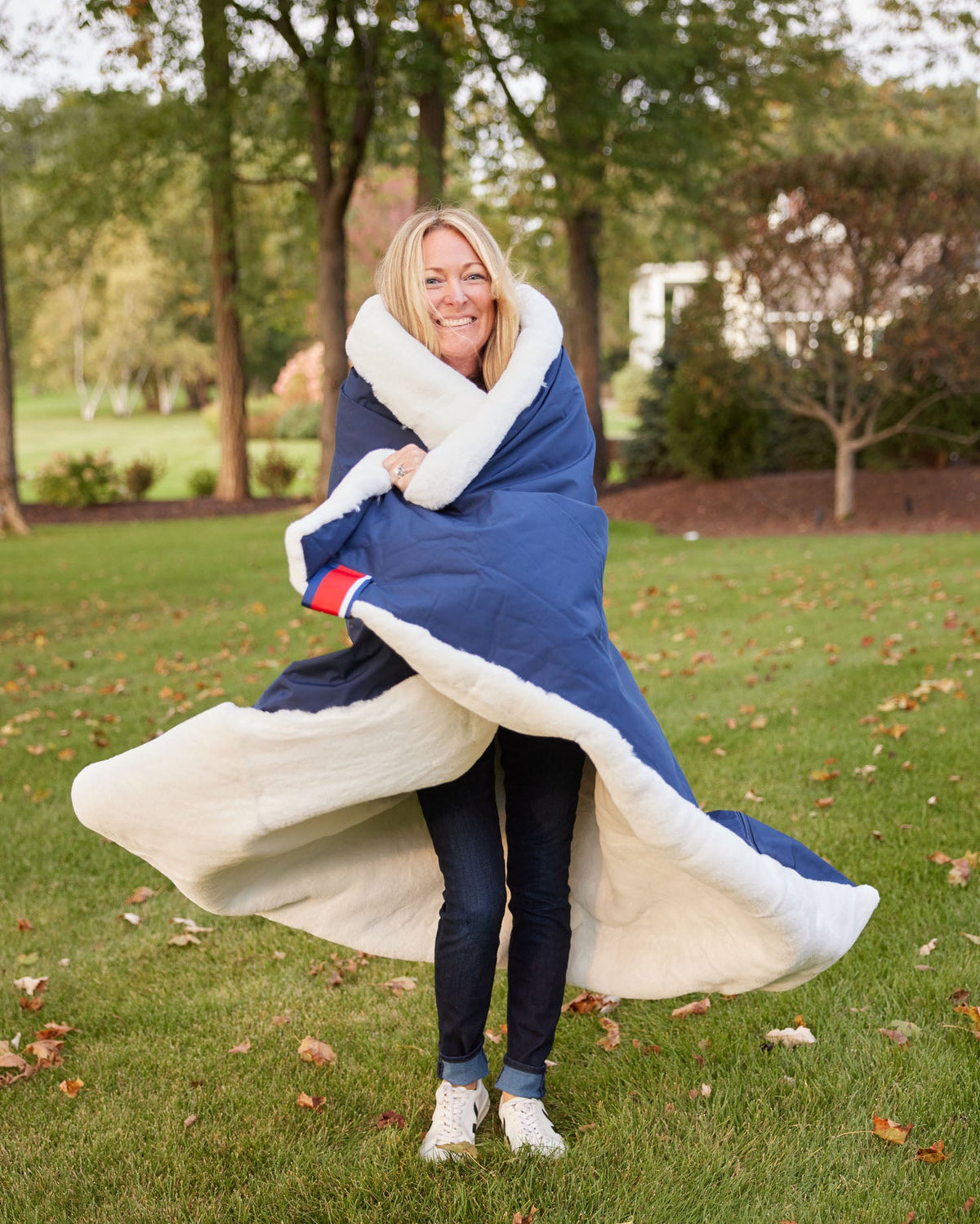 Blue outdoor blanket with white plush lining wrapped around a person