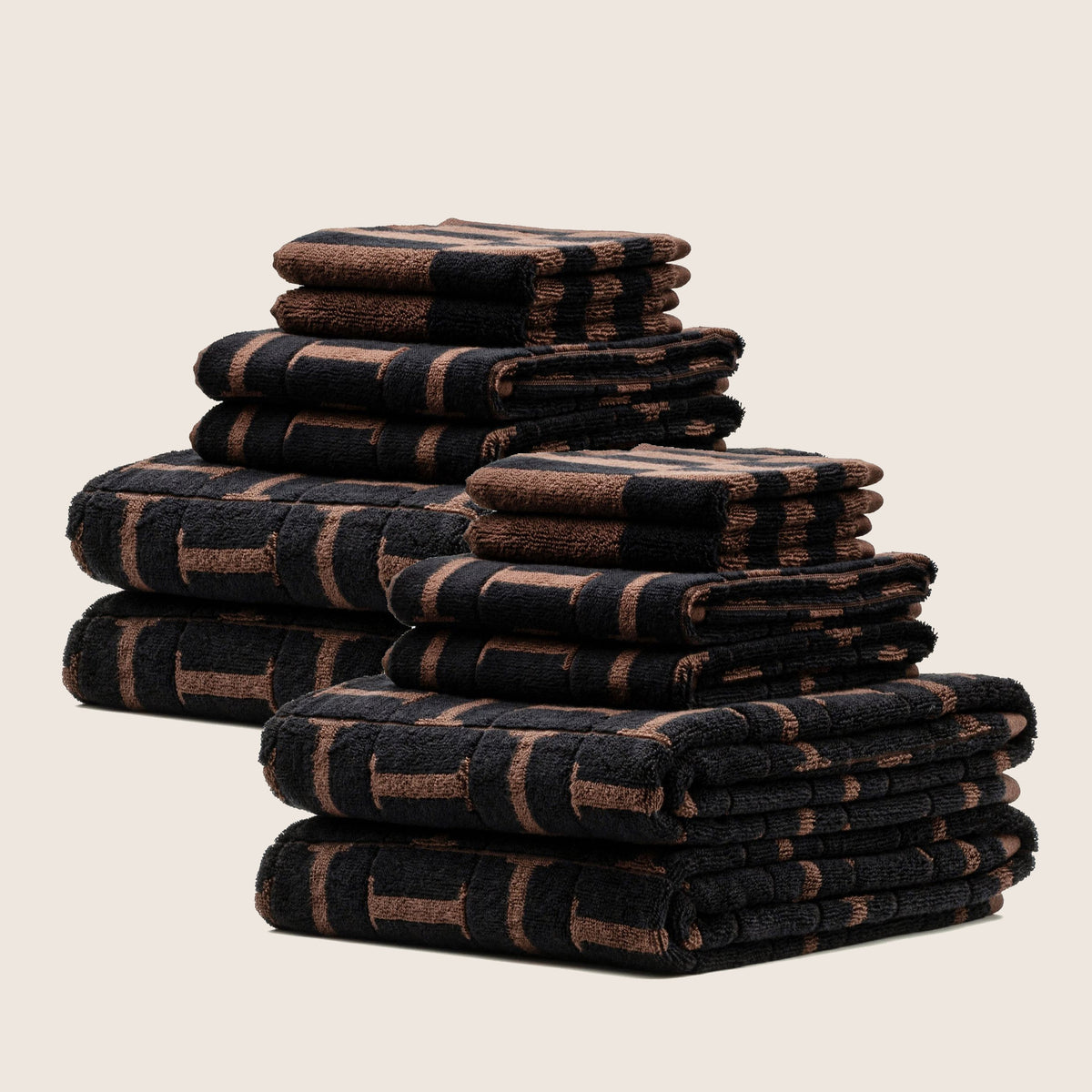 Folded cotton towels in tobacco and black with vertical stripe blocks, stacked in layers