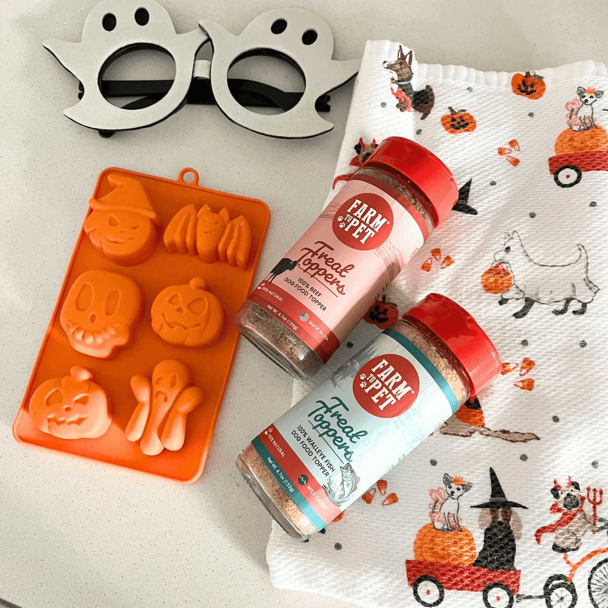 Orange silicone pet treat mold tray with paw and bone-shaped impressions