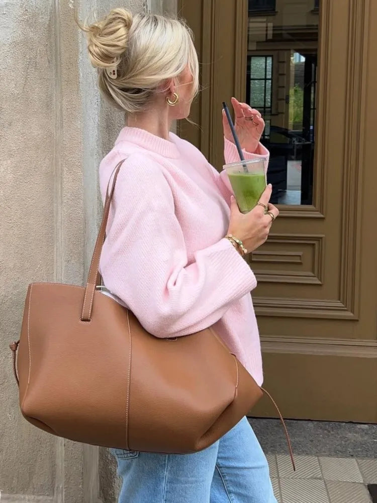 Women’s pink knitted O-neck sweater with long sleeves and relaxed fit