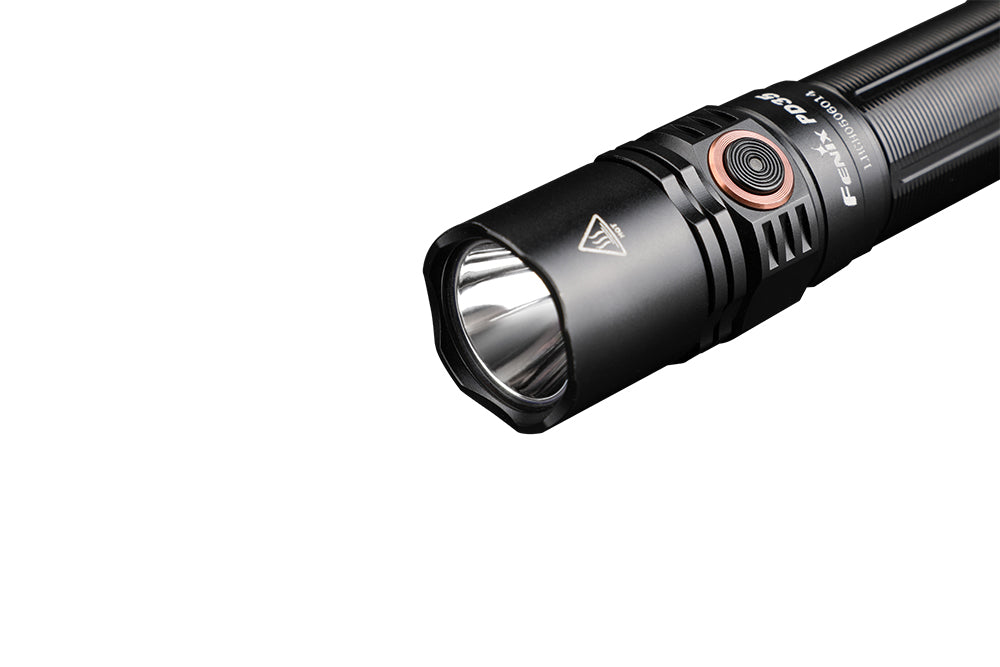 Flashlight head close-up with black bezel and reflective lens, orange ring detail