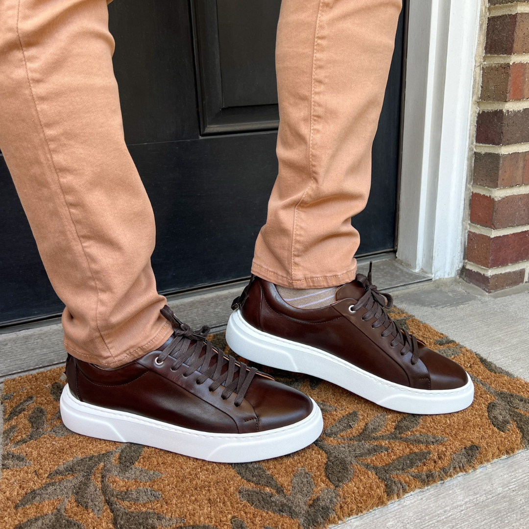 Men's dark brown lace-up leather sneakers with white sole, ankle view