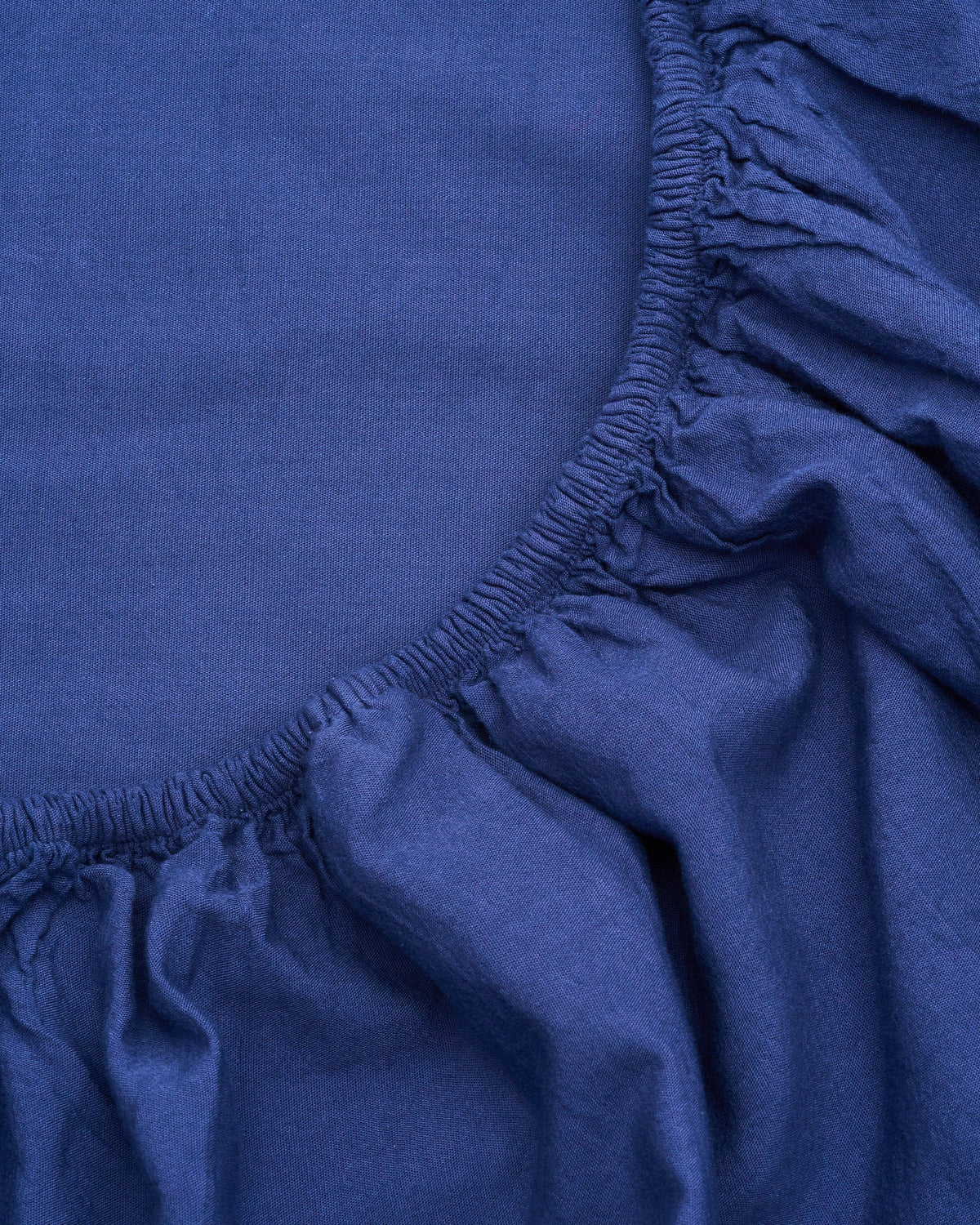 Dark blue milk-fibre fitted sheet edge with gathered elastic