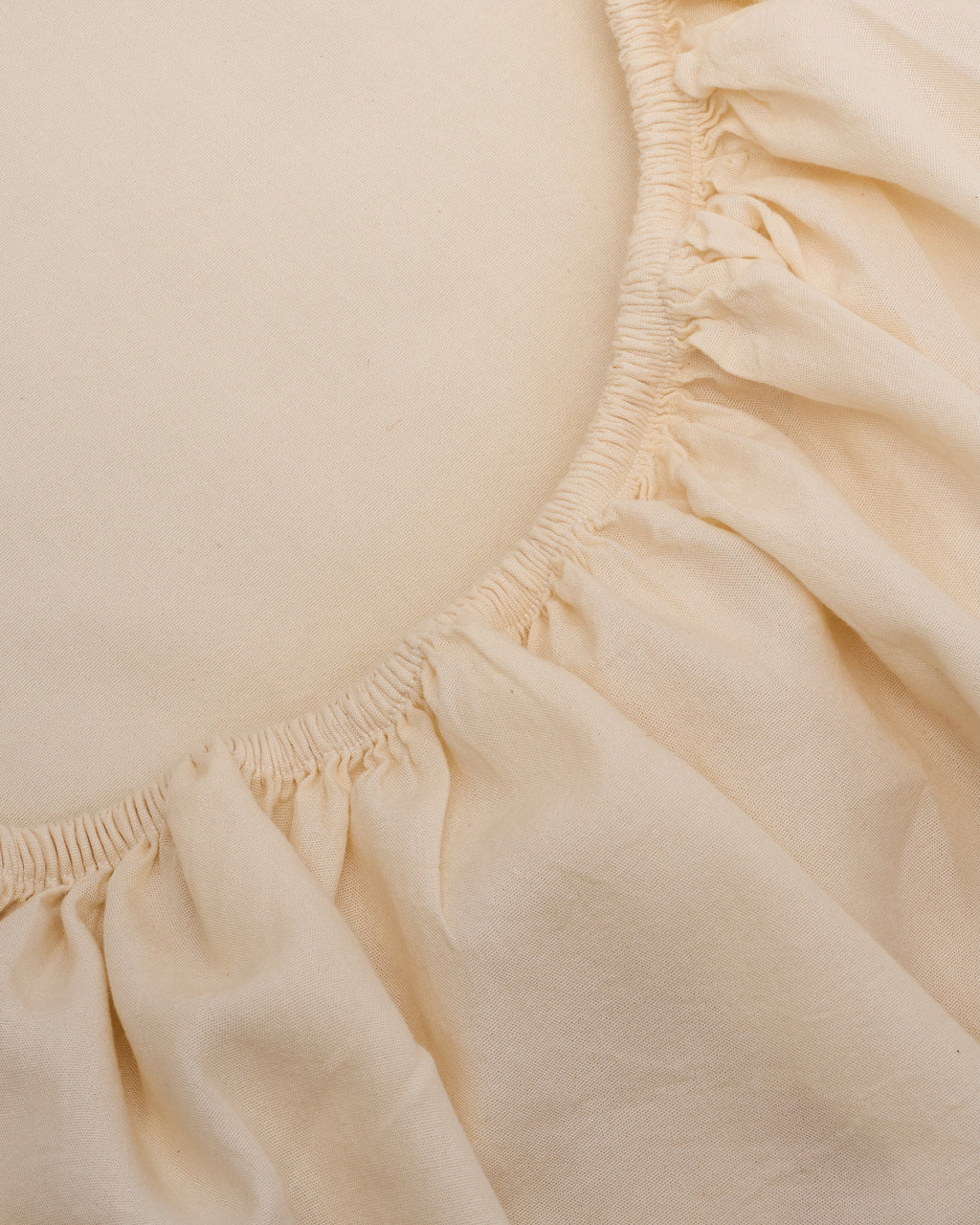 Cream sheet close-up with elastic edge and gathered skirt ruffle