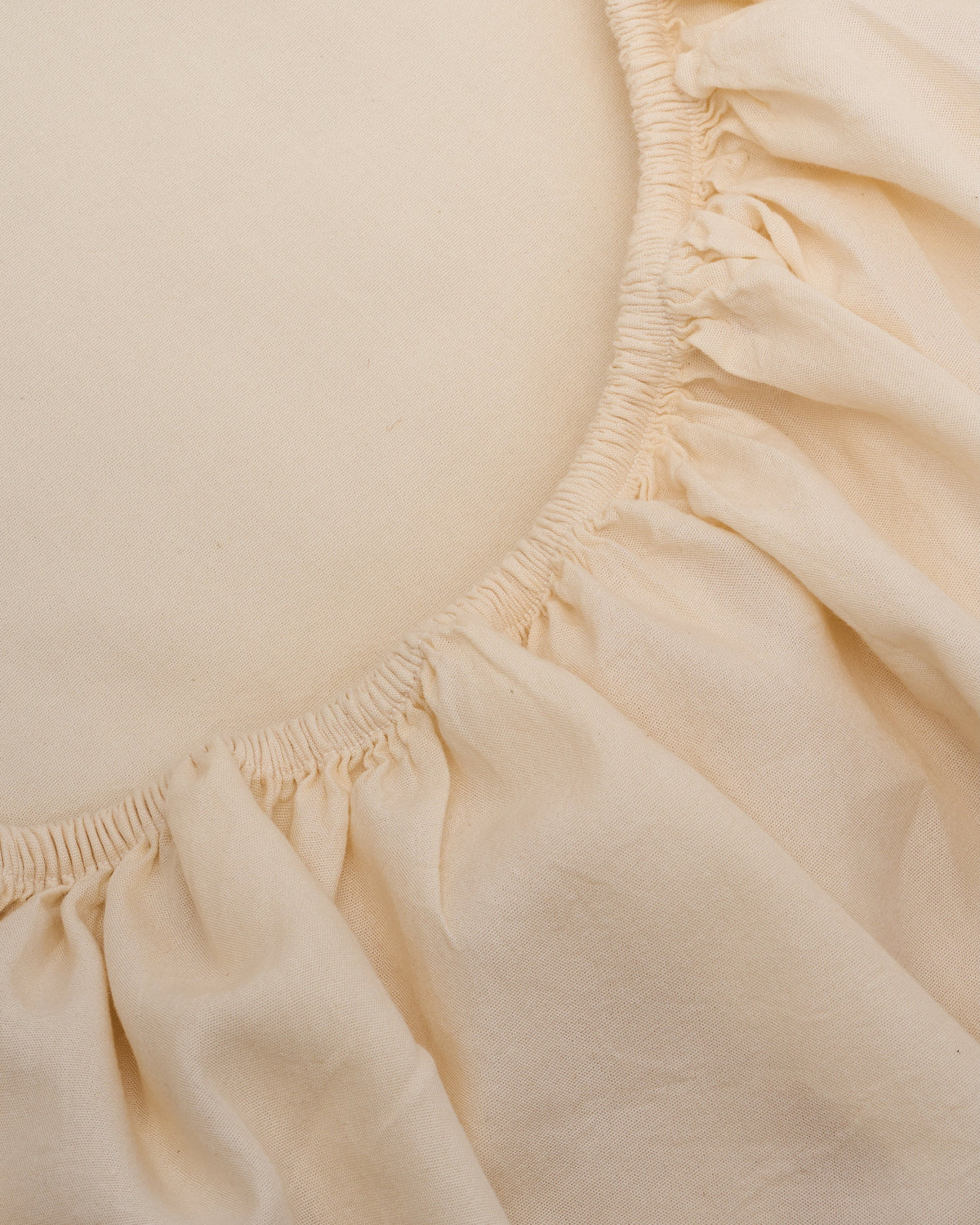Cream sheet close-up with elastic edge and gathered skirt ruffle