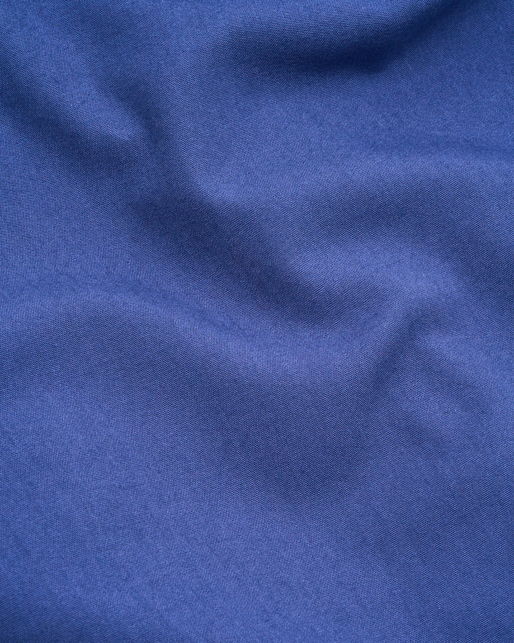 Dark blue milk-fibre fabric close-up with smooth textured weave