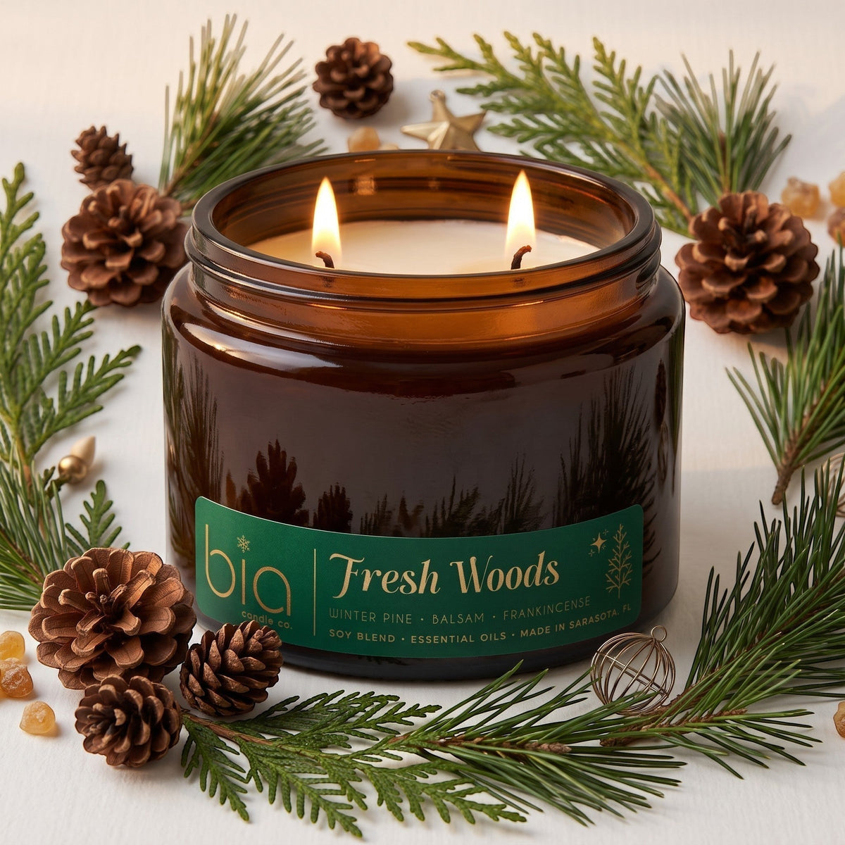 Amber candle jar with green label and pine cone decor, burning flame