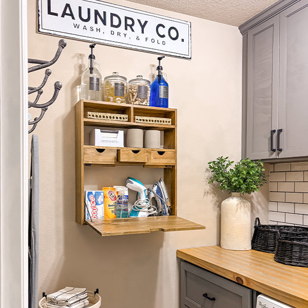 Wall-mounted fold-down wood shelf with open compartments and storage bins