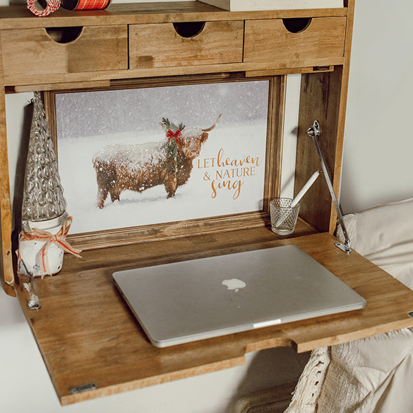 Fold-down wood shelf desk with open panel and wooden surface holding a laptop