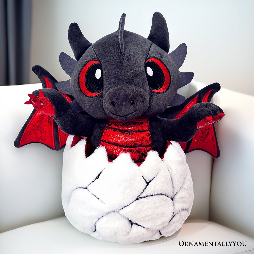 Black plush dinosaur with red wings and large red eyes, in white egg-shaped stuffed body