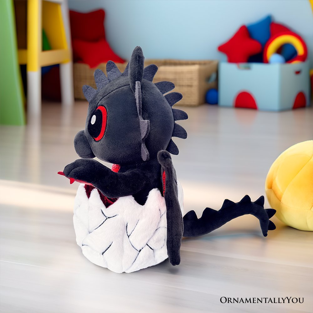 Black dinosaur plush with red eyes and red wing accents, standing in white egg-shaped body