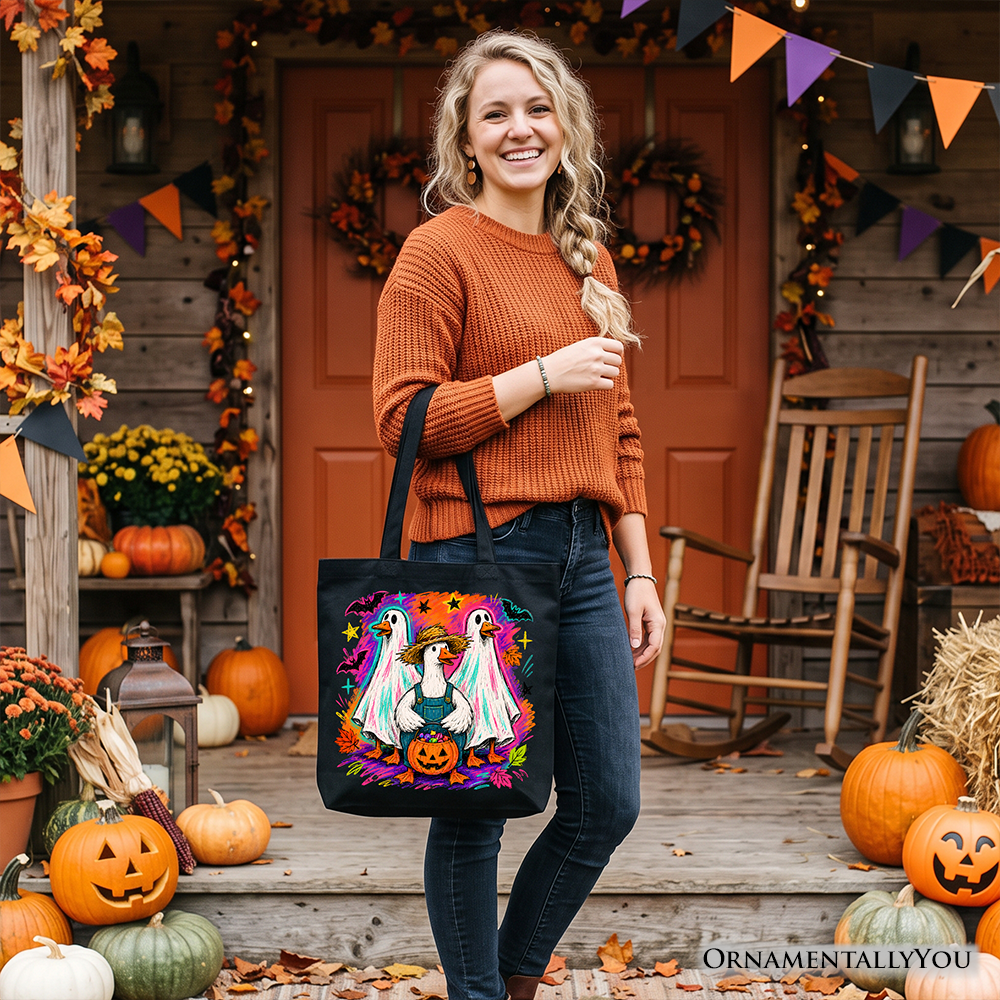 Black tote bag with colorful goose family artwork and teal pumpkin detail.