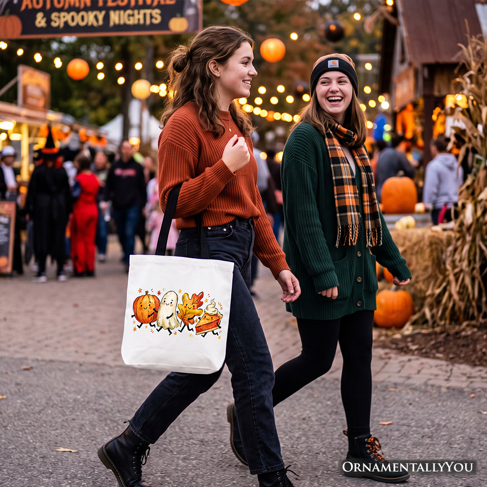 White tote bag with black handles on a person, decorated with pumpkin ghost and autumn leaves