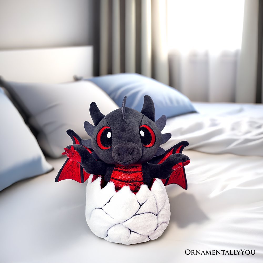 Black plush dinosaur with red wings and red-ringed eyes, in white egg-shaped stuffed body